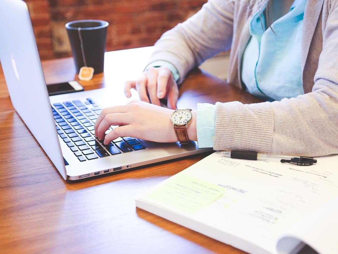Office worker surrounded by paperwork and manual data entry tasks